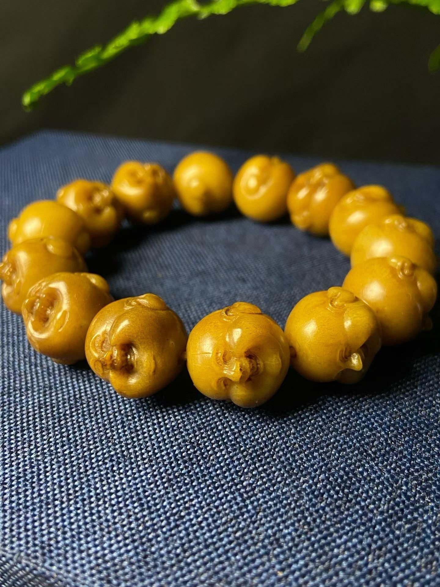 Bracelet of amber-yellow beads, each carved into a laughing face