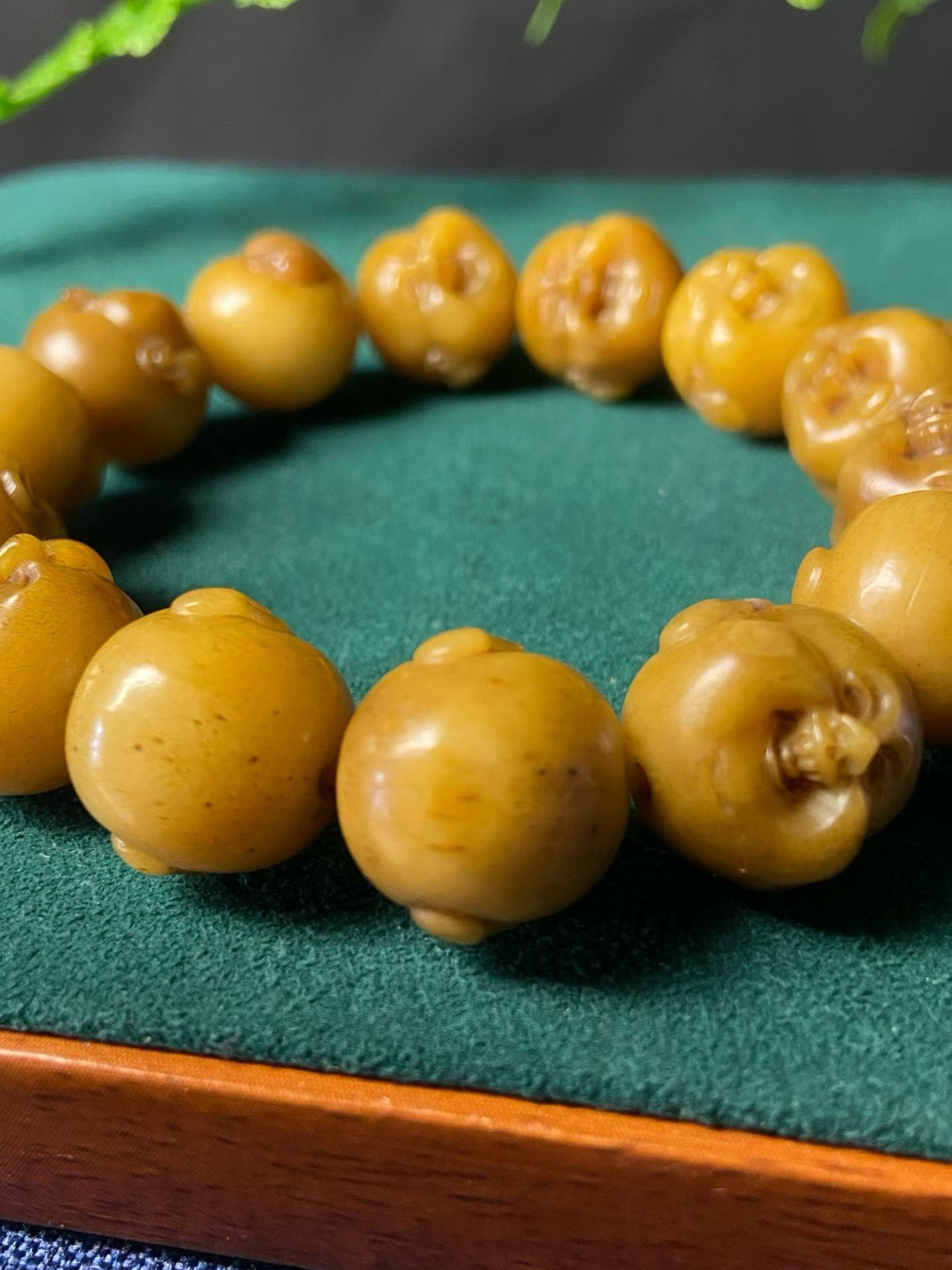Bracelet of amber-yellow beads, each carved into a laughing face
