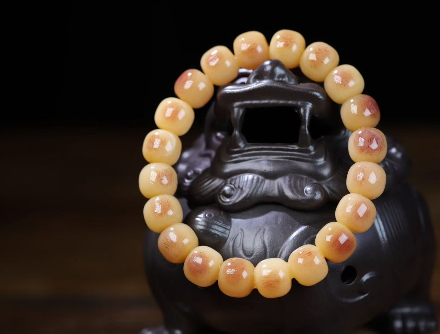 Bracelet of small cream beads with shallow carved relief patterns