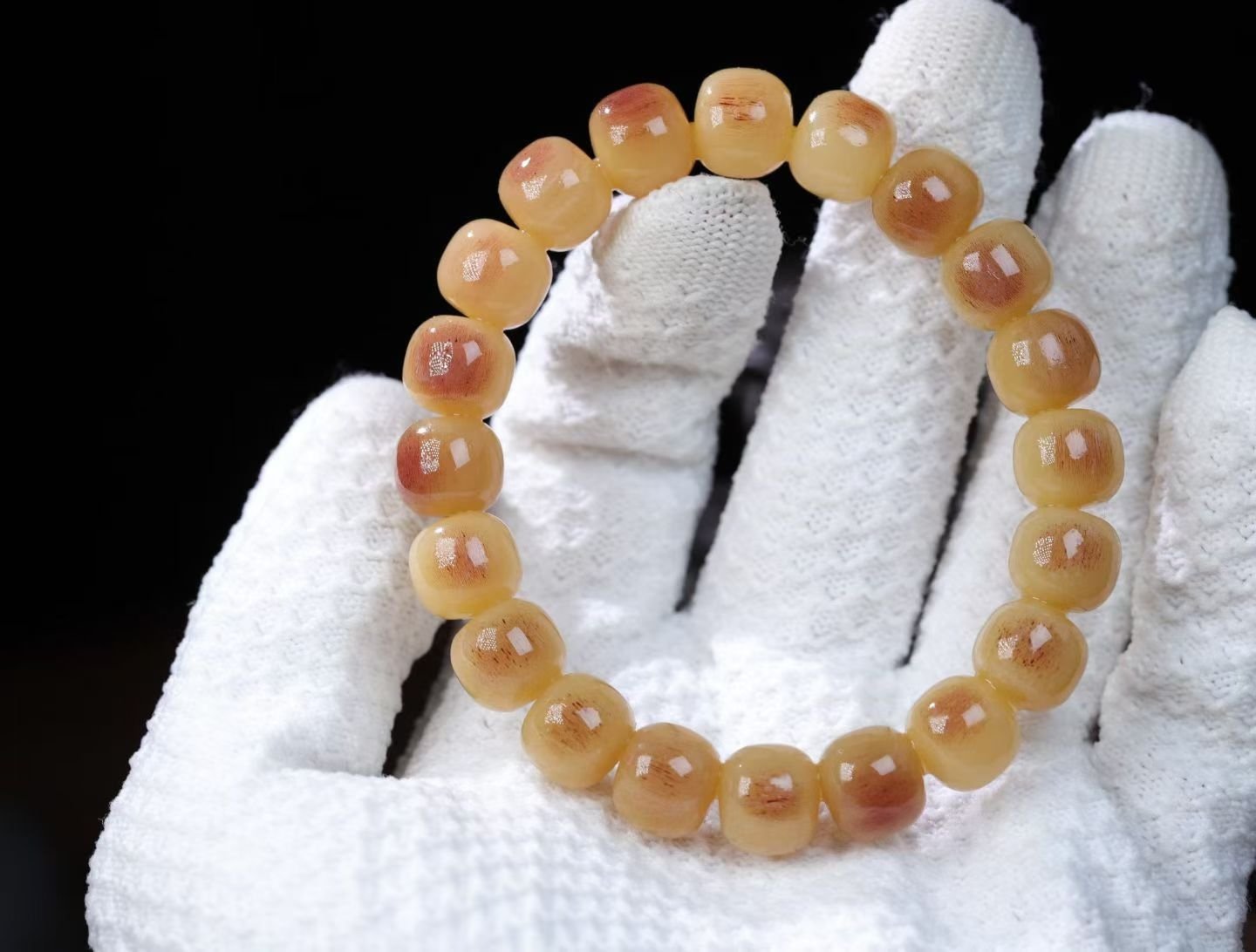 Bracelet of small cream beads with shallow carved relief patterns