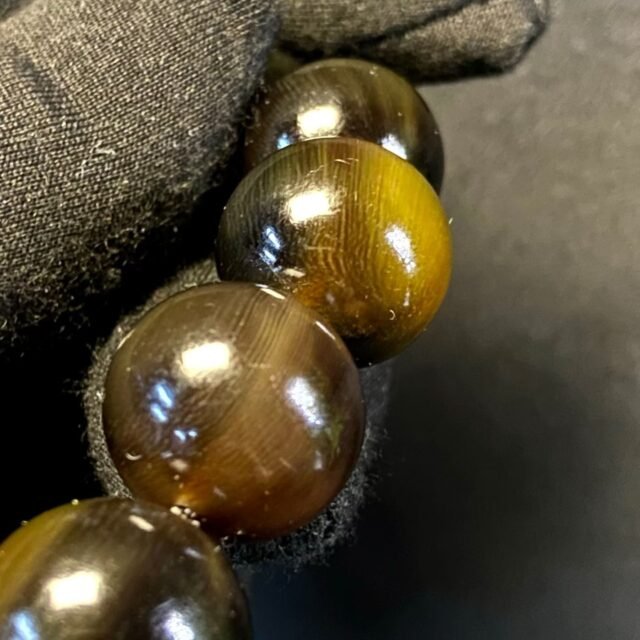 Dark translucent horn beads with a red ring and a pale carved beast head