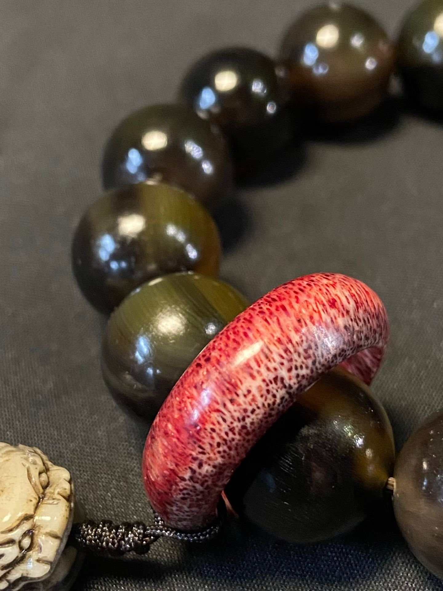 Dark translucent horn beads with a red ring and a pale carved beast head