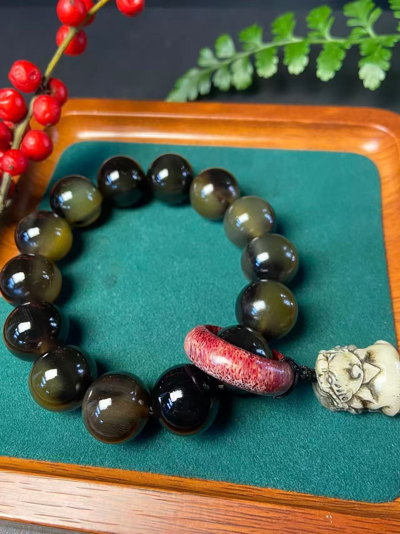 Dark translucent horn beads with a red ring and a pale carved beast head