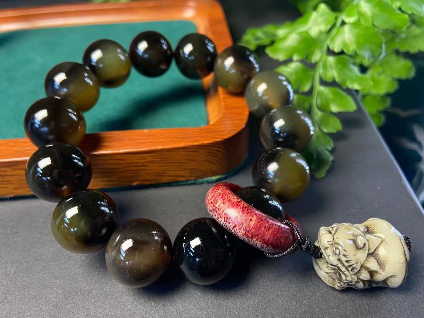 Dark translucent horn beads with a red ring and a pale carved beast head