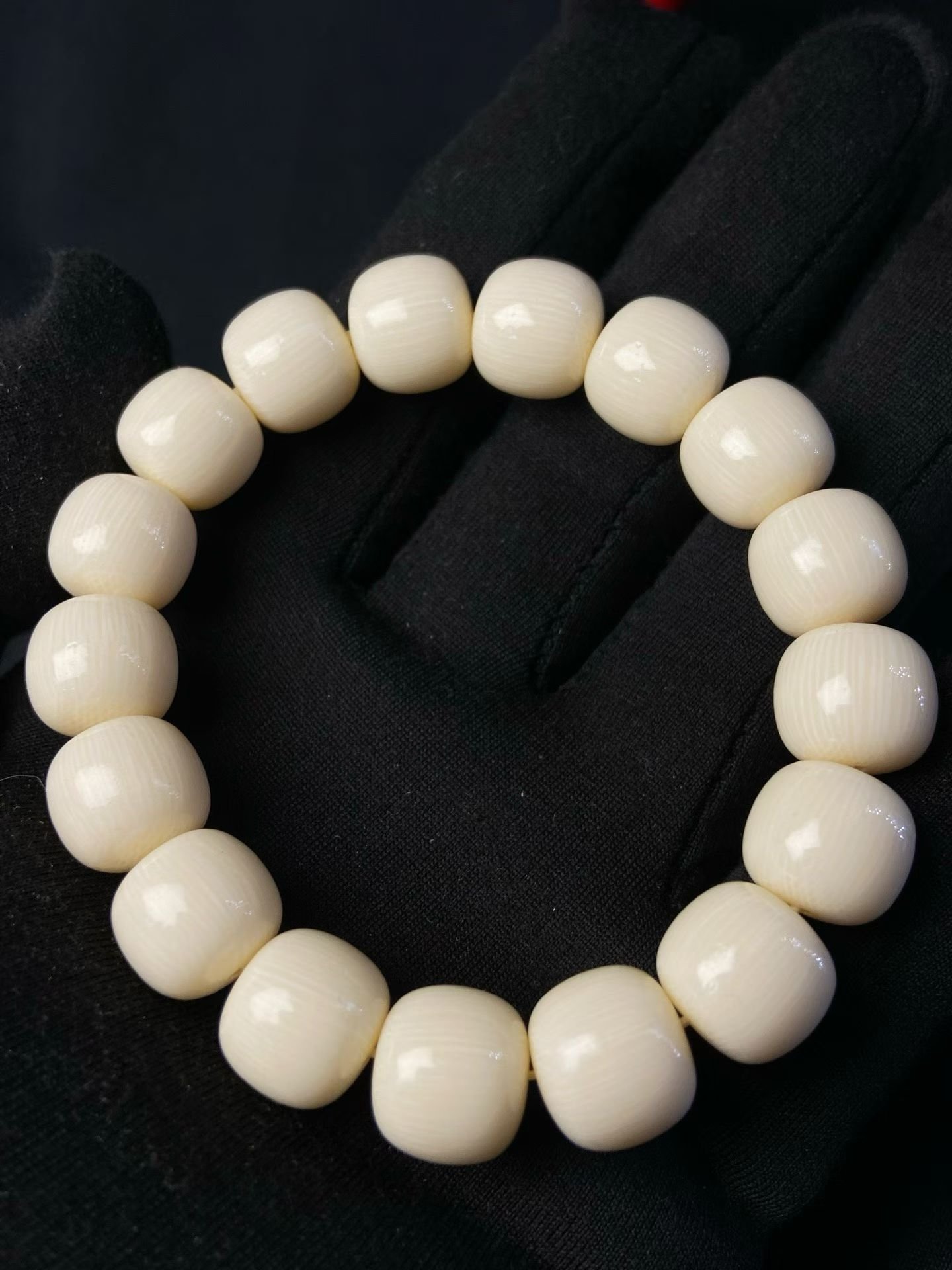 Cream barrel-shaped beads each with a single dark eye-shaped marking